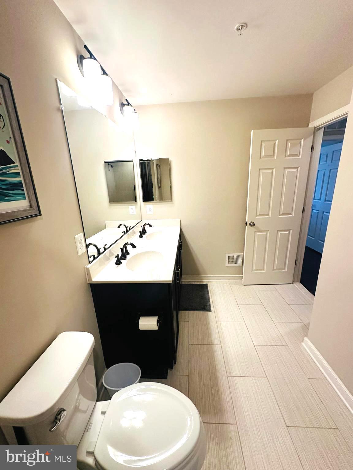 25576 Tolar Square Chantilly, VA 20152 - Photo 20 of 36 a bathroom with a sink a toilet a mirror and vanity