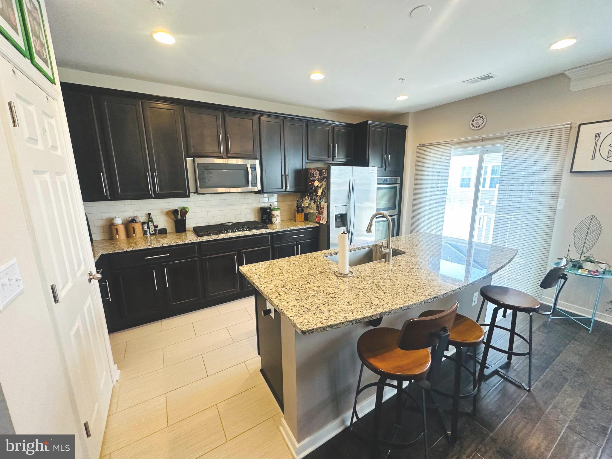 25576 Tolar Square Chantilly, VA 20152 - Photo 2 of 36 a kitchen with a table chairs sink and refrigerator
