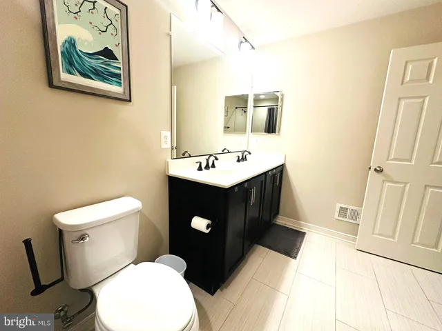 a bathroom with a sink mirror vanity and toilet