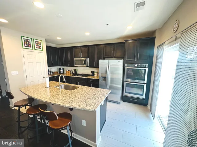 a kitchen with kitchen island a counter top space appliances and cabinets