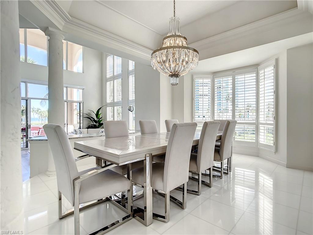 21 Casa Mar Lane, Unit 21 Naples, FL 34103 - Photo 14 of 47 a view of a dining room with furniture wooden floor and chandelier
