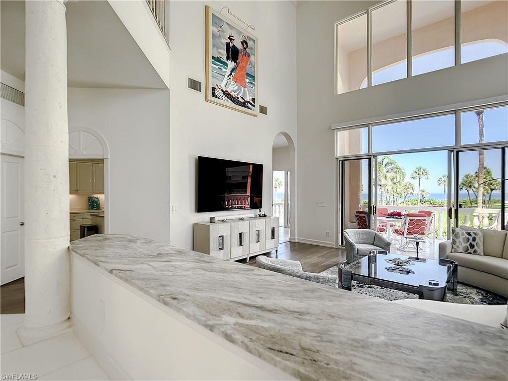 21 Casa Mar Lane, Unit 21 Naples, FL 34103 - Photo 15 of 47 a living room with furniture and a flat screen tv