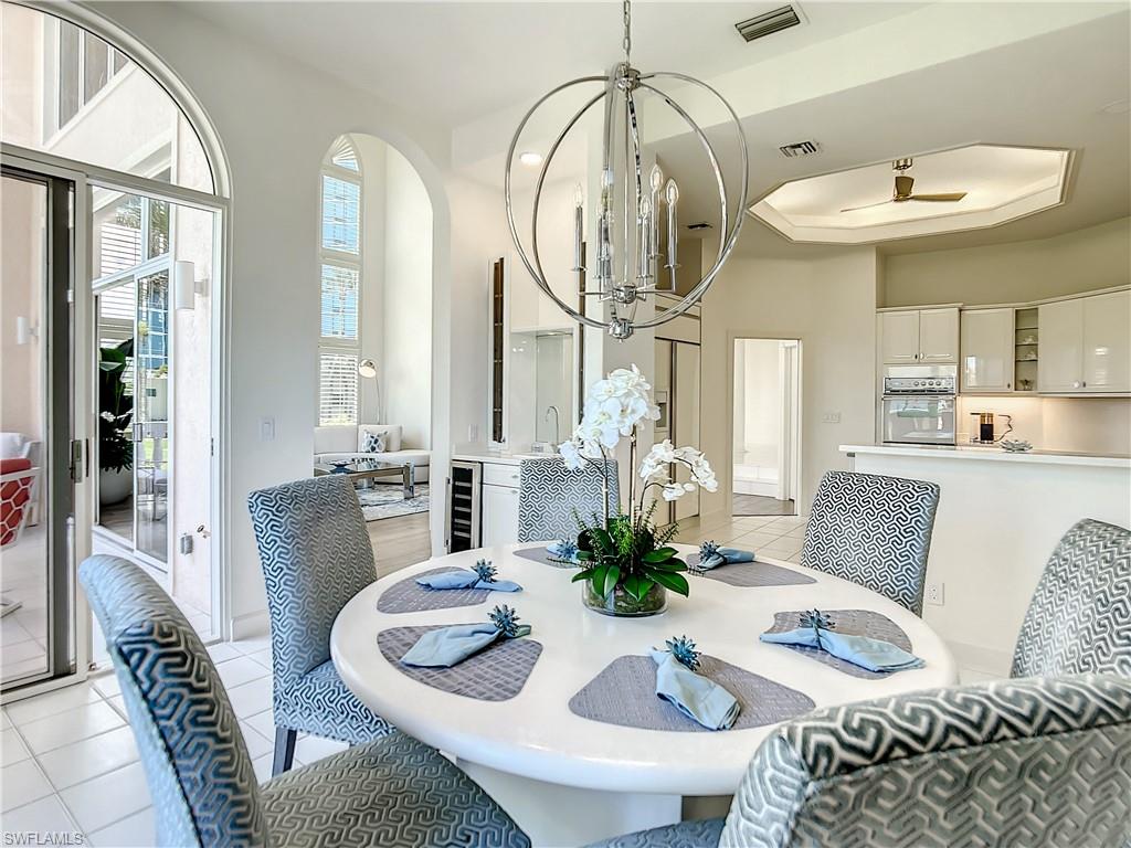 21 Casa Mar Lane, Unit 21 Naples, FL 34103 - Photo 21 of 47 a living room with furniture chandelier and a dining table