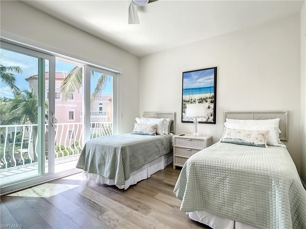 21 Casa Mar Lane, Unit 21 Naples, FL 34103 - Photo 25 of 47 a bedroom with two beds and a large window