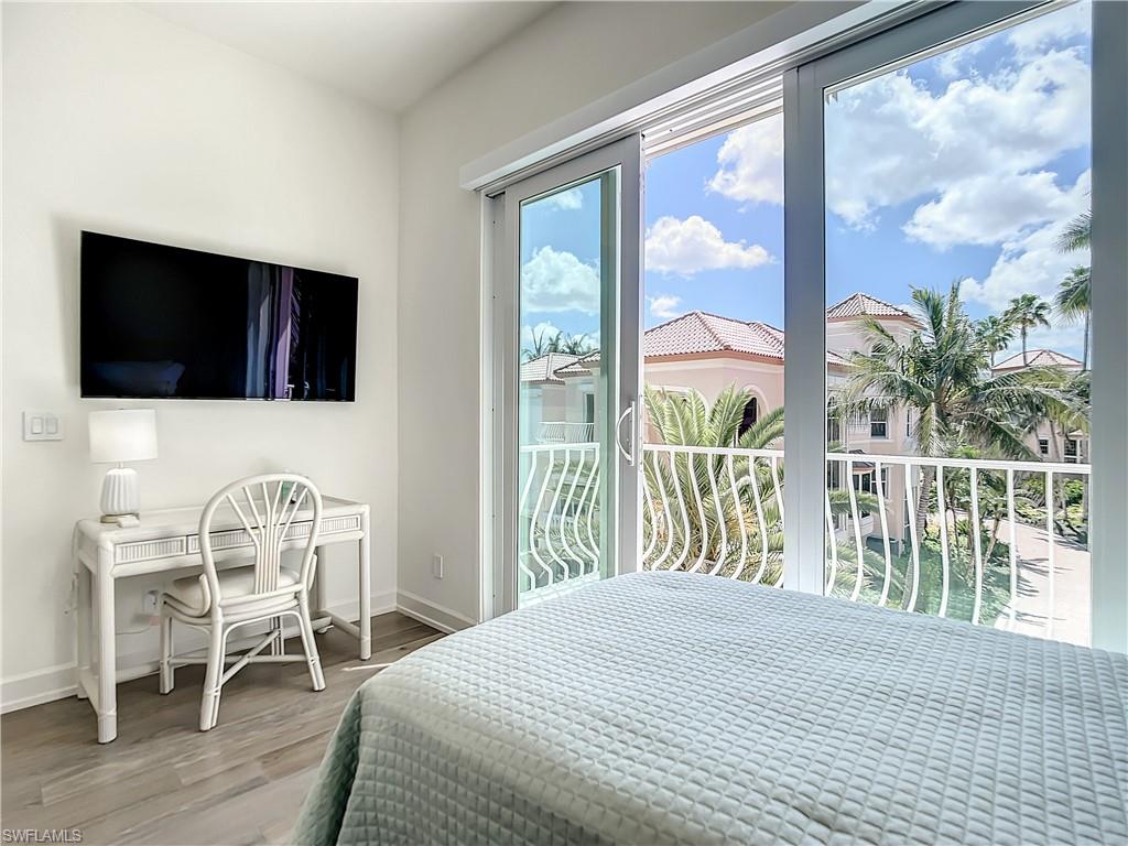 21 Casa Mar Lane, Unit 21 Naples, FL 34103 - Photo 26 of 47 a bedroom with a bed and a large window with outer view