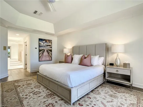 a large white bathroom with a tub a sink and a large mirror