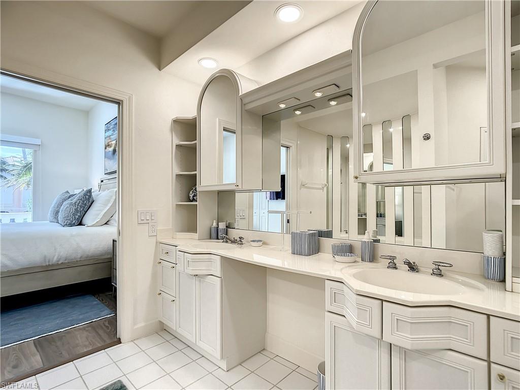 21 Casa Mar Lane, Unit 21 Naples, FL 34103 - Photo 32 of 47 a bathroom with a sink vanity and mirror