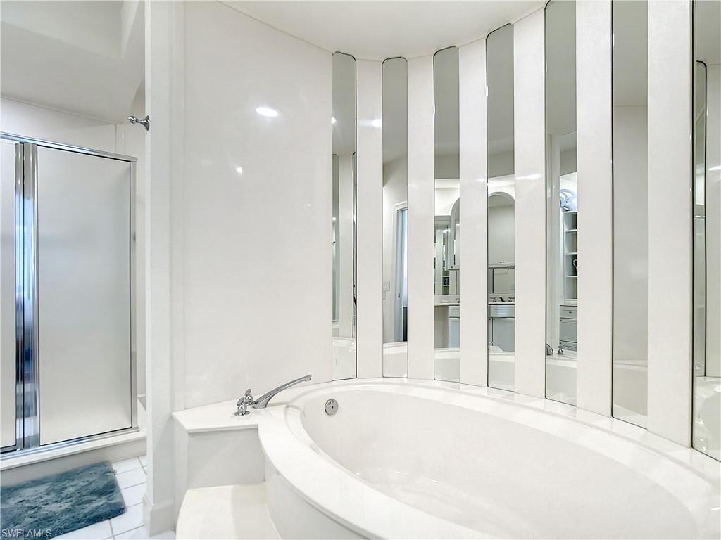 21 Casa Mar Lane, Unit 21 Naples, FL 34103 - Photo 33 of 47 a white bath tub sitting next to a toilet