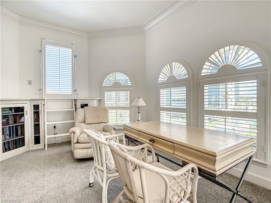 21 Casa Mar Lane, Unit 21 Naples, FL 34103 - Photo 34 of 47 a living room with furniture a fireplace and a large window