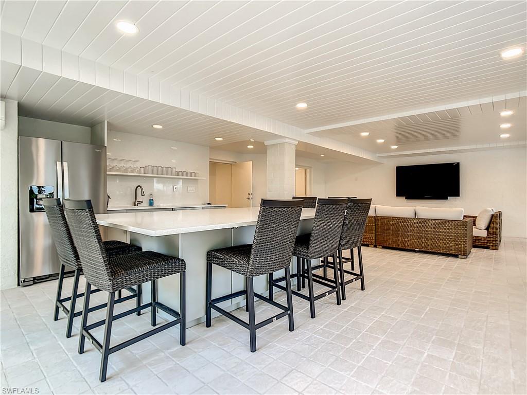 21 Casa Mar Lane, Unit 21 Naples, FL 34103 - Photo 37 of 47 a open kitchen with stainless steel appliances kitchen island granite countertop a table and chairs in it