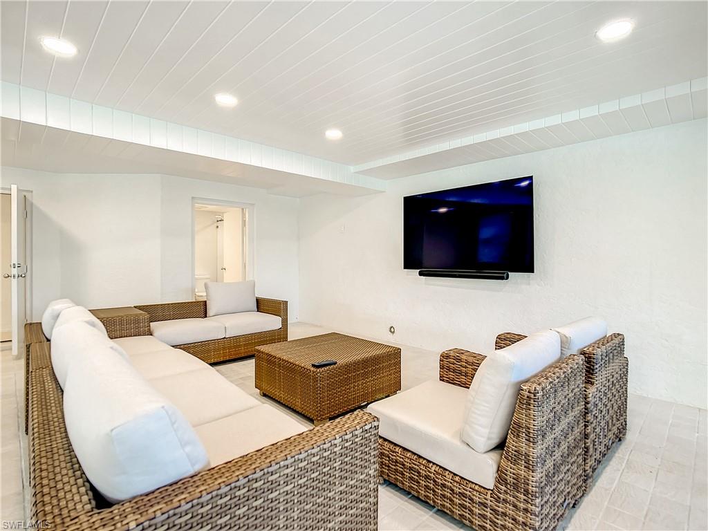 21 Casa Mar Lane, Unit 21 Naples, FL 34103 - Photo 38 of 47 a living room with furniture and a flat screen tv