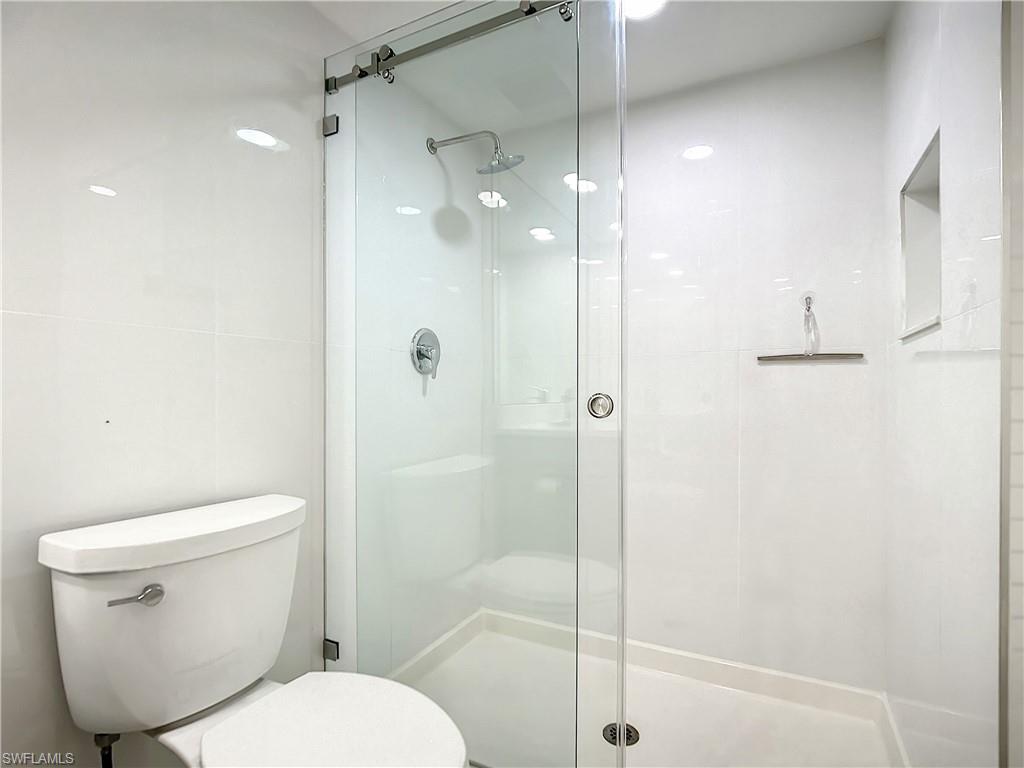 21 Casa Mar Lane, Unit 21 Naples, FL 34103 - Photo 41 of 47 a white toilet sitting next to a bathroom sink