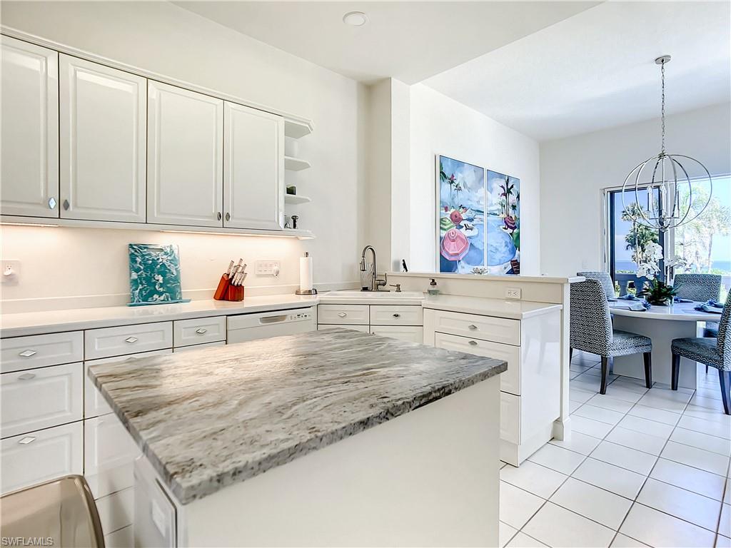 21 Casa Mar Lane, Unit 21 Naples, FL 34103 - Photo 10 of 47 a kitchen with stainless steel appliances granite countertop a sink dishwasher and cabinets with wooden floor