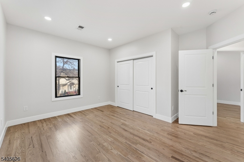 228 Locust Street Roselle, NJ 07203 - Photo 13 of 35 a view of an empty room with wooden floor and a window