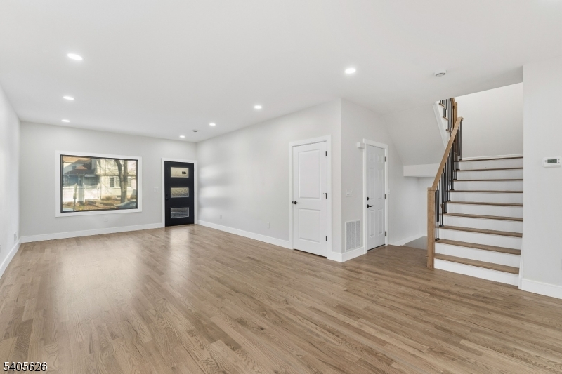 228 Locust Street Roselle, NJ 07203 - Photo 5 of 35 an empty room with wooden floor and windows