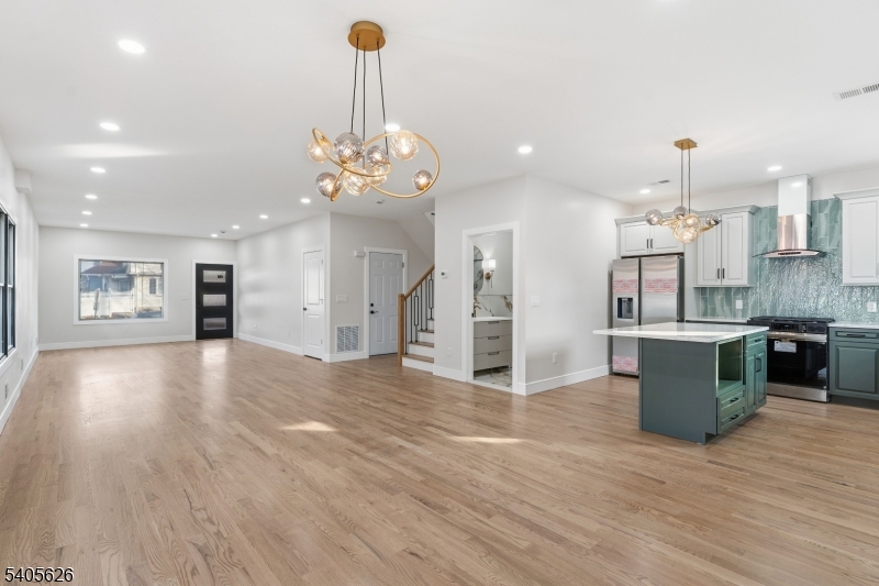 228 Locust Street Roselle, NJ 07203 - Photo 8 of 35 a view of a kitchen with stainless steel appliances granite countertop a refrigerator a sink dishwasher a oven and a dining table with wooden floor