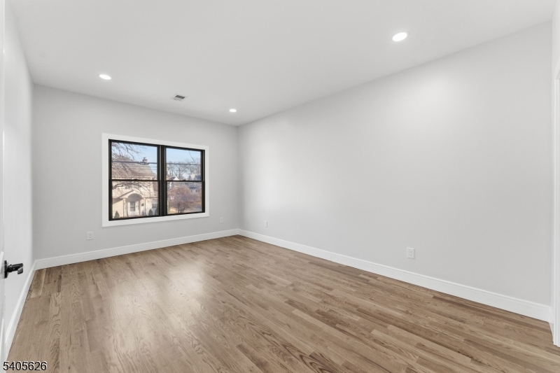 228 Locust Street Roselle, NJ 07203 - Photo 10 of 35 a view of an empty room with wooden floor and a window