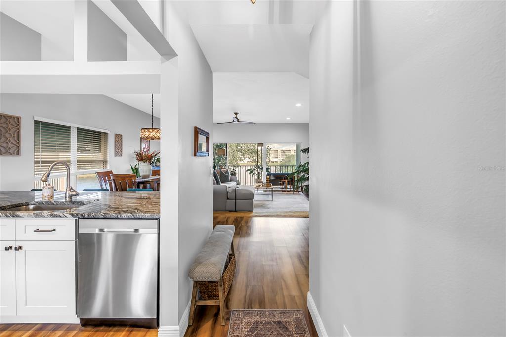 6311 99th Way North, Unit 11A St. Petersburg, FL 33708 - Photo 11 of 52 a kitchen with stainless steel appliances granite countertop a refrigerator a stove a sink dishwasher and white cabinets with wooden floor