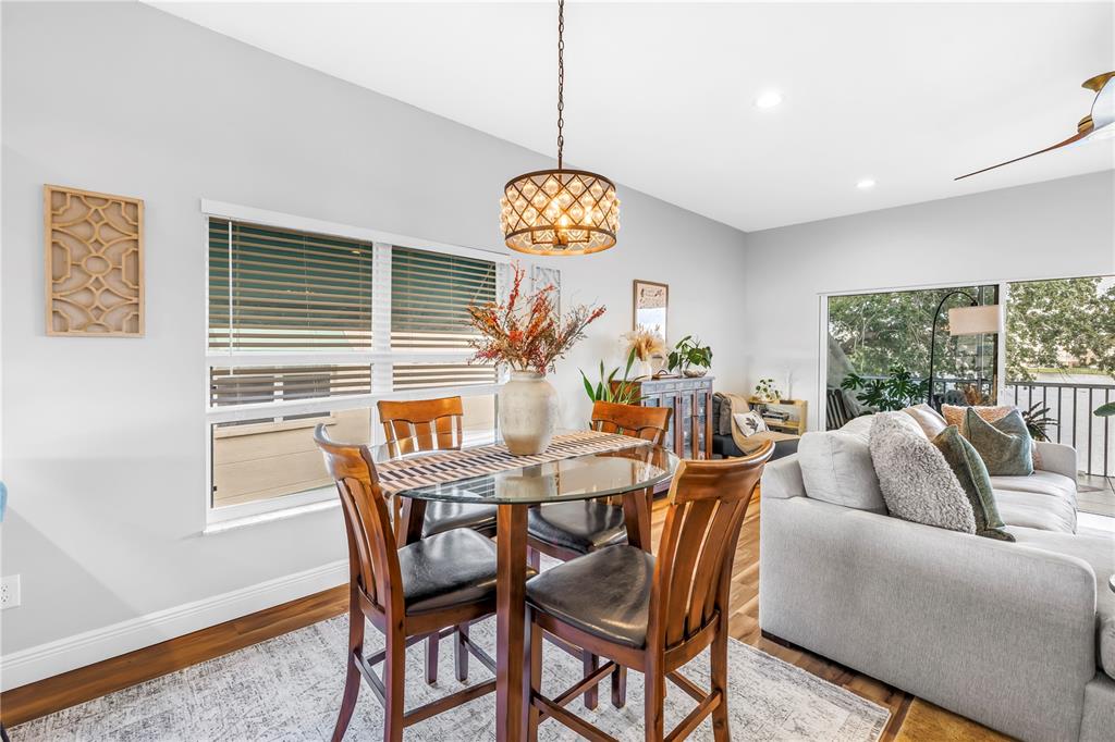 6311 99th Way North, Unit 11A St. Petersburg, FL 33708 - Photo 12 of 52 a view of a dining room with furniture wooden floor and chandelier