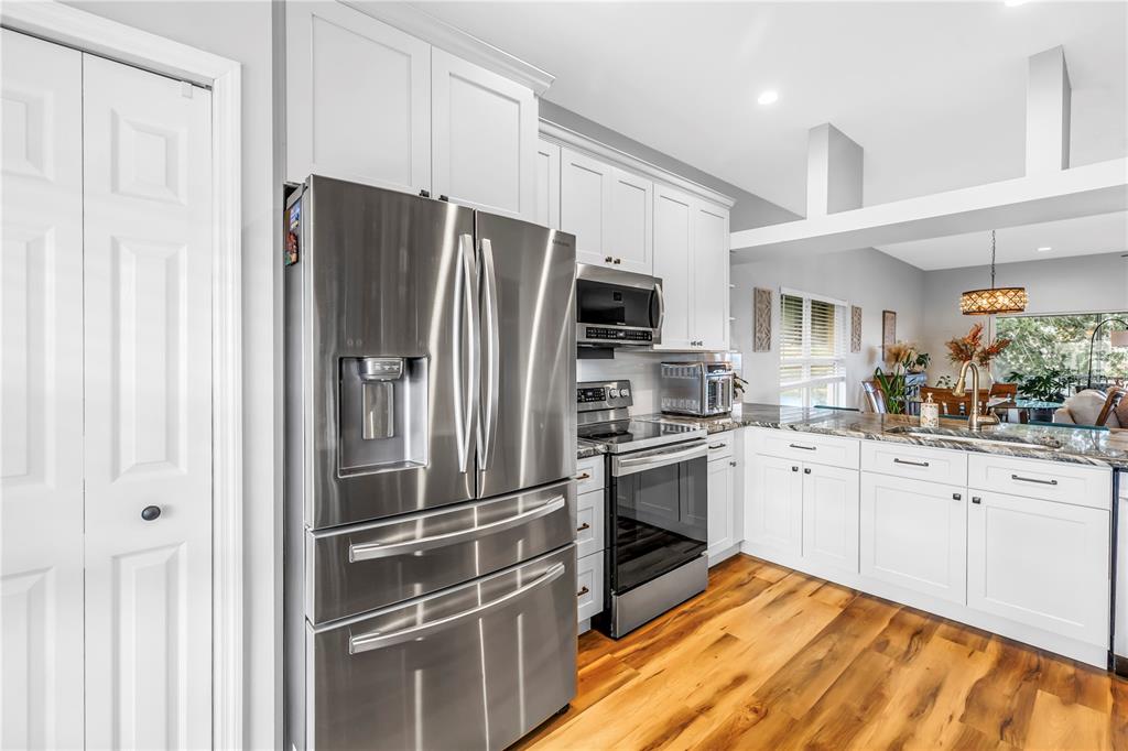 6311 99th Way North, Unit 11A St. Petersburg, FL 33708 - Photo 18 of 52 a kitchen with stainless steel appliances a refrigerator sink and cabinets