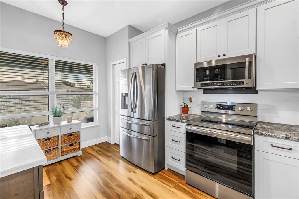 6311 99th Way North, Unit 11A St. Petersburg, FL 33708 - Photo 19 of 52 a kitchen with granite countertop a refrigerator stove and microwave