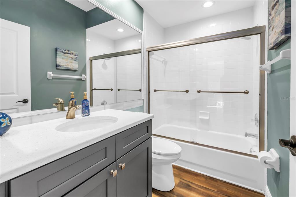 6311 99th Way North, Unit 11A St. Petersburg, FL 33708 - Photo 32 of 52 a bathroom with a sink mirror toilet and next to a large window