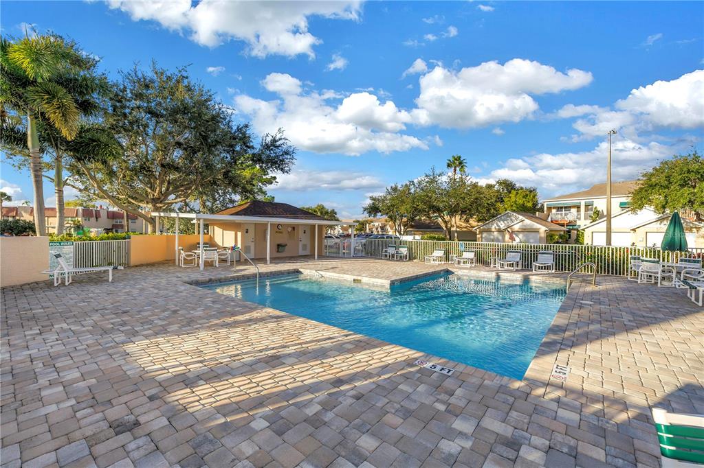 6311 99th Way North, Unit 11A St. Petersburg, FL 33708 - Photo 41 of 52 a view of yard with swimming pool and trees in the background