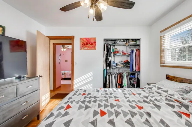 a bedroom with a bed and a flat tv screen on dresser