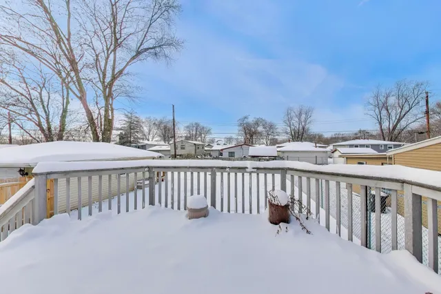 a view of roof deck with wooden fence and trees
