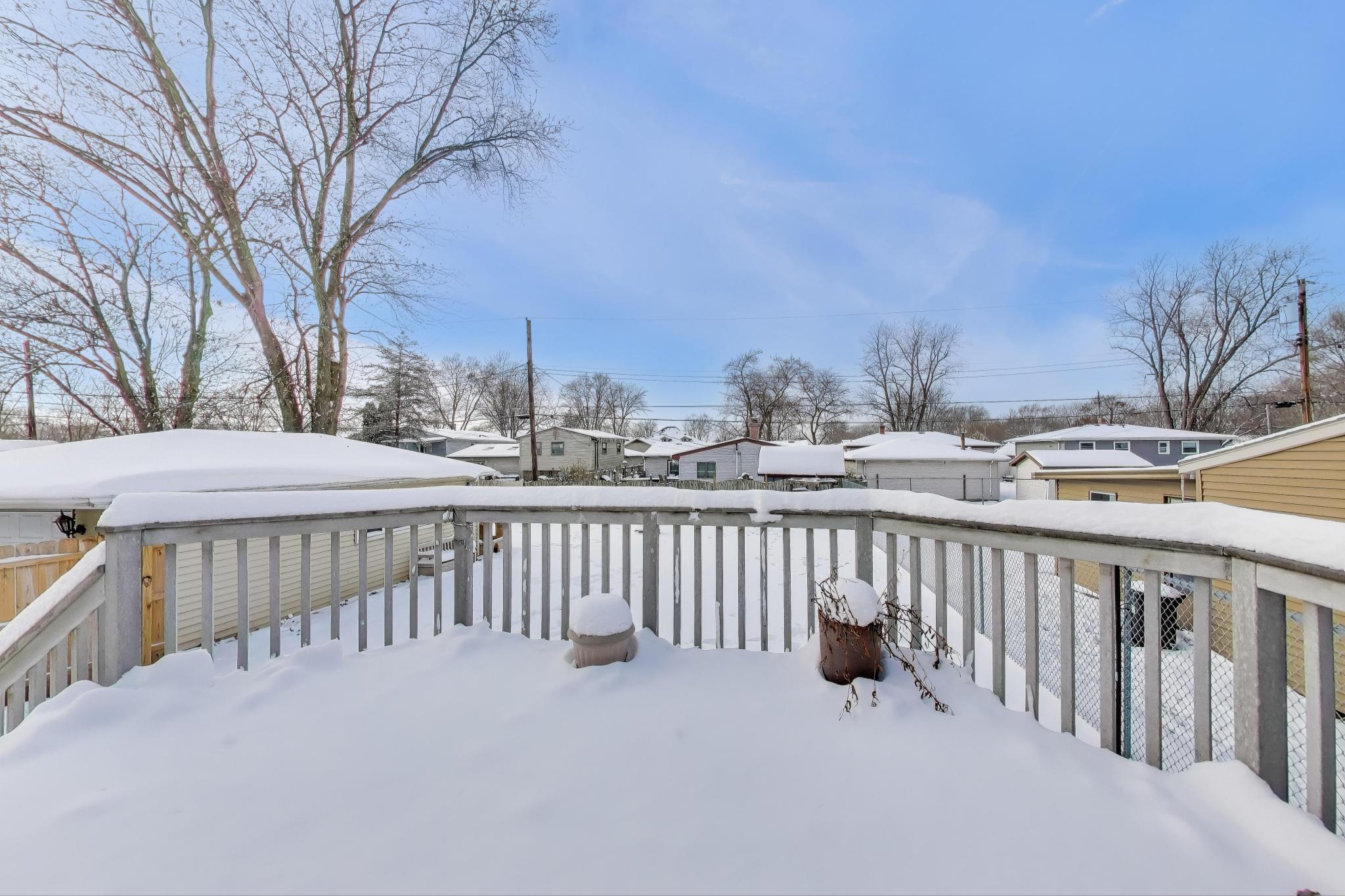 1044 North Rensselaer Street Griffith, IN 46319 - Photo 23 of 32 a view of roof deck with wooden fence and trees