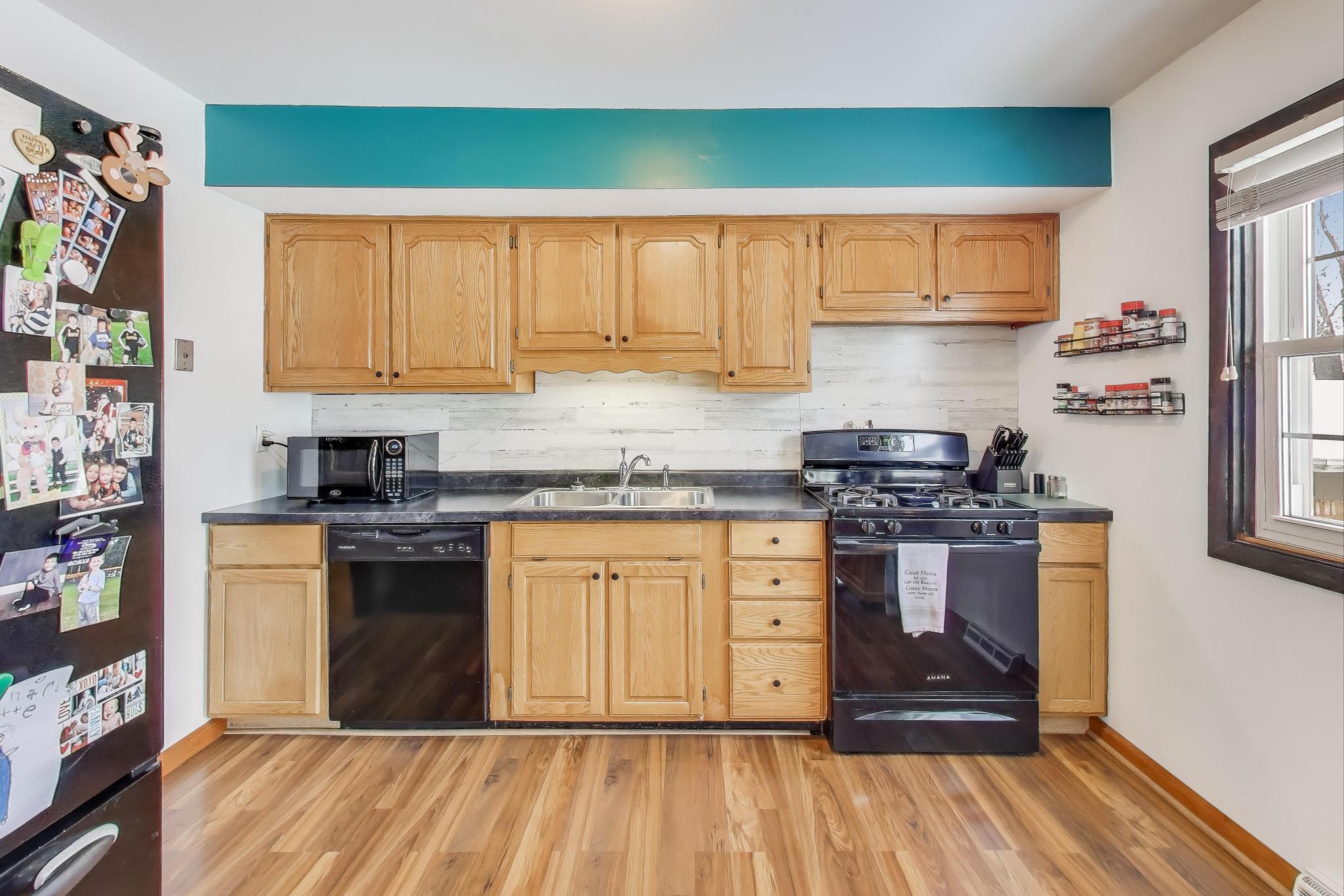 1044 North Rensselaer Street Griffith, IN 46319 - Photo 8 of 32 a kitchen with stainless steel appliances granite countertop a stove a sink and a refrigerator