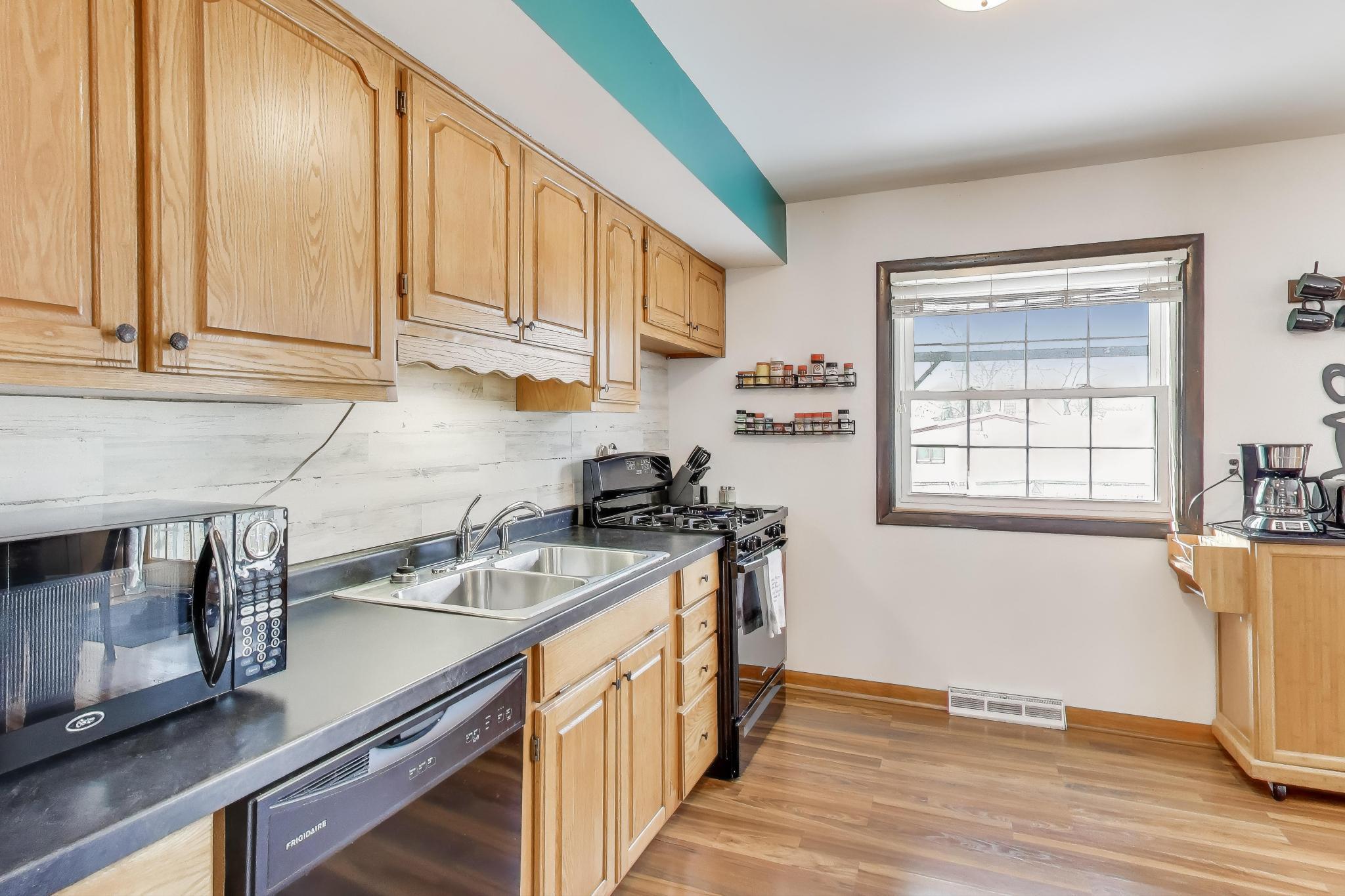 1044 North Rensselaer Street Griffith, IN 46319 - Photo 10 of 32 a kitchen with stainless steel appliances granite countertop a sink a stove and a wooden floors