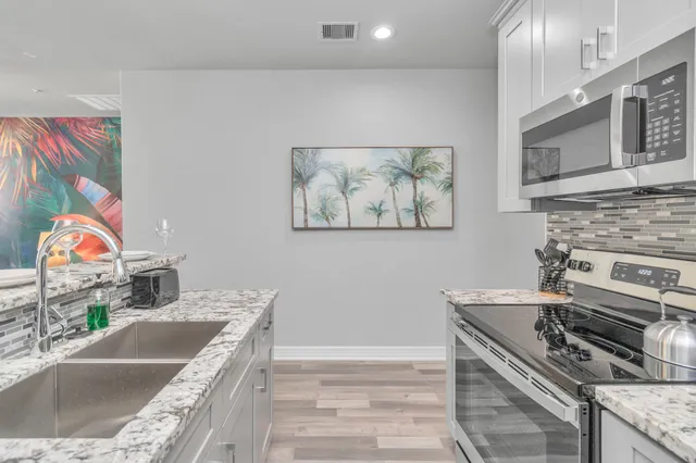 a kitchen with stainless steel appliances granite countertop a stove and a sink