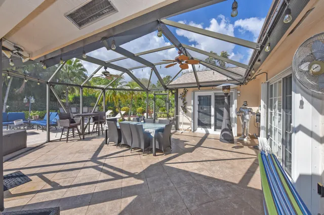 a view of a patio with a table and chairs under an umbrella