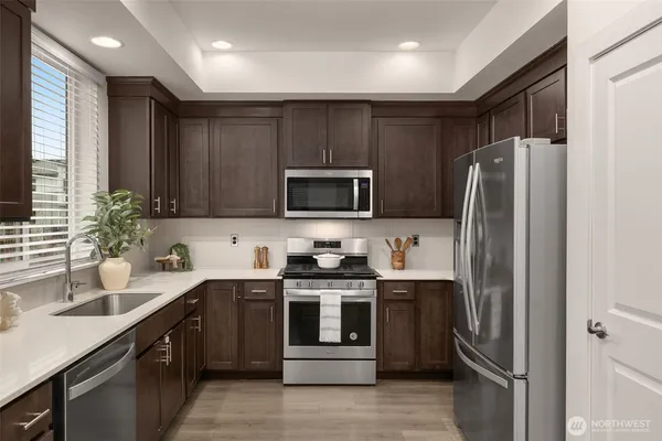 a kitchen with stainless steel appliances a refrigerator stove and microwave