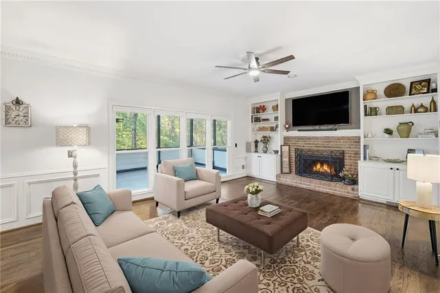 a living room with furniture a flat screen tv and a fireplace