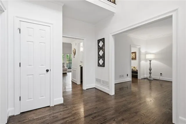 a view of an empty room with wooden floor and a bathroom