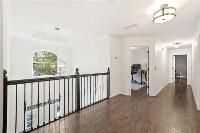 a view of a hallway with wooden floor and a chandelier