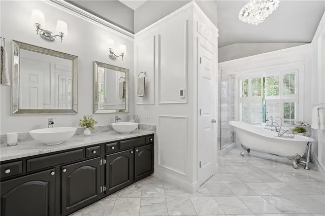 a spacious bathroom with a double vanity sink a mirror and a bathtub
