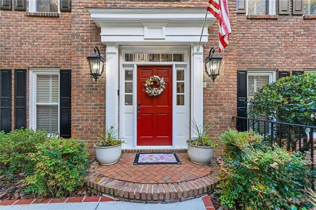a view of a brick house with potted plants