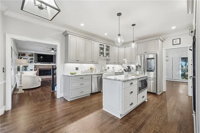 a kitchen with stainless steel appliances white cabinets and wooden floors