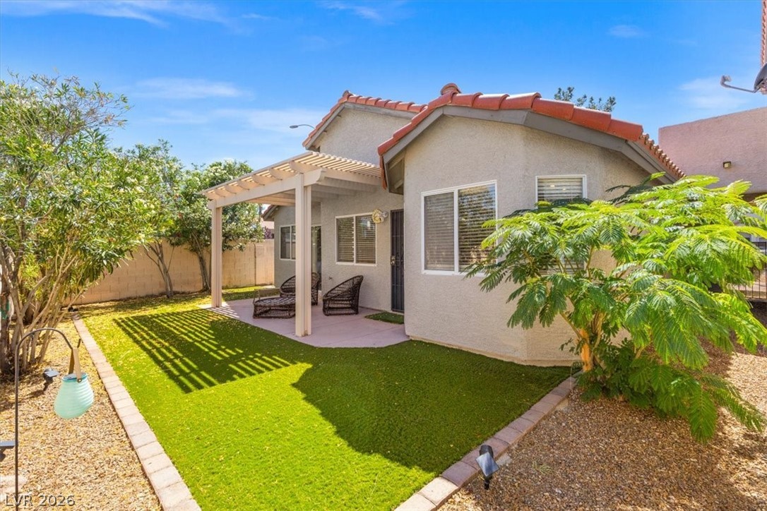 2377 Ramsgate Drive Henderson, NV 89074 - Photo 22 of 25 A well-maintained yard offers artificial turf and a shaded patio area, perfect for unwinding outdoors.