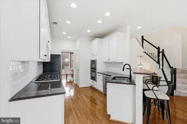 a large kitchen with stainless steel appliances granite countertop a stove and a sink