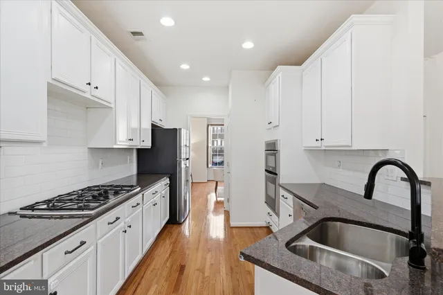 a living room with furniture a flat screen tv and windows