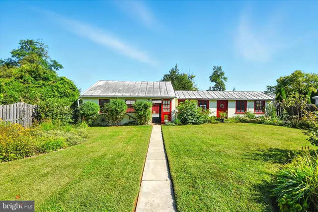 a front view of a house with a yard and potted plants