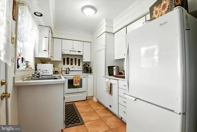 a kitchen with white cabinets and white appliances