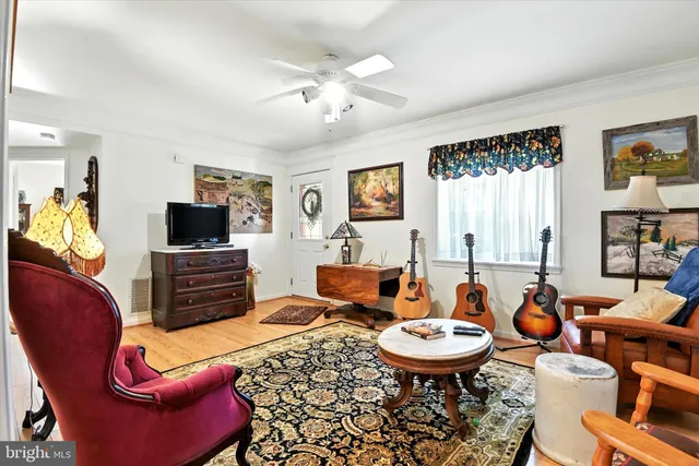 a living room with furniture a flat screen tv and a dining table