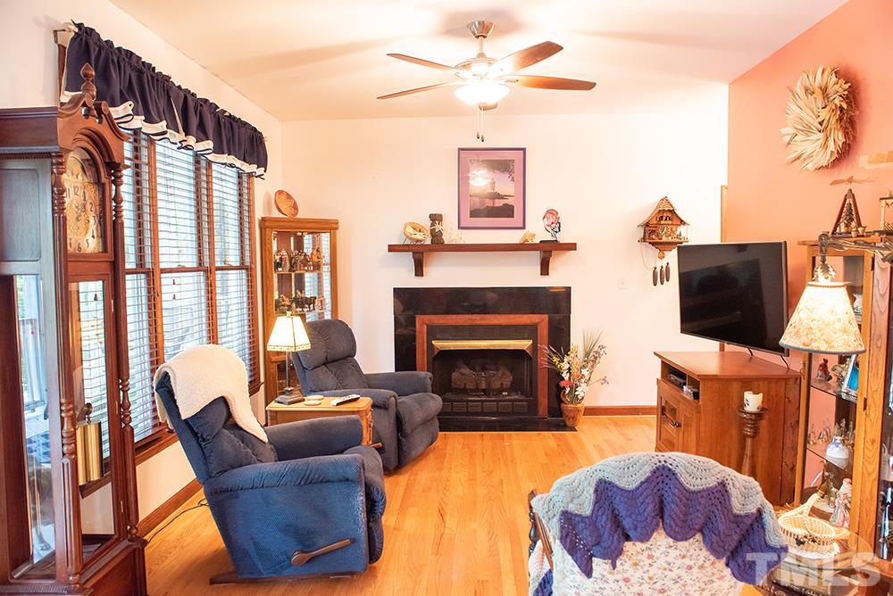 169 Willifords Point Road Roxboro, NC 27574 - Photo 11 of 30 a living room with furniture a flat screen tv and a fireplace
