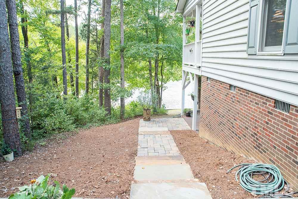 169 Willifords Point Road Roxboro, NC 27574 - Photo 27 of 30 a view of a pathway of a house with plants and large trees