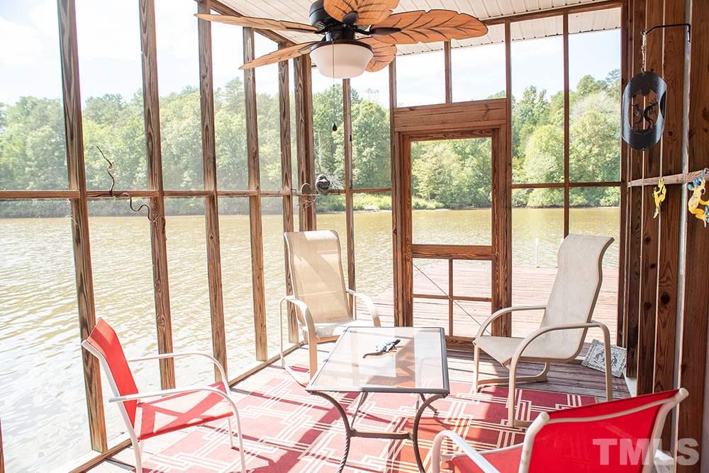 169 Willifords Point Road Roxboro, NC 27574 - Photo 5 of 30 a living room filled with furniture and floor to ceiling windows
